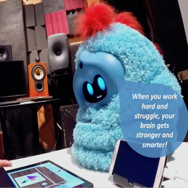 A fluffy blue Tega robot smiles and says 'When you work hard and struggle, your brain gets stronger and smarter!'