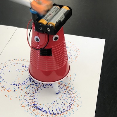 Battery powered robot made out of a solo cup and drawing with markers.